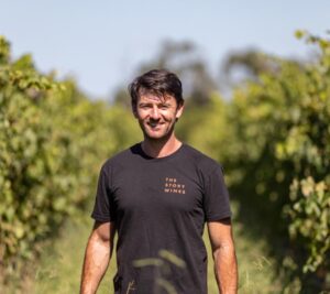 Rory Lane from The Story Wines standing between vineyard rows