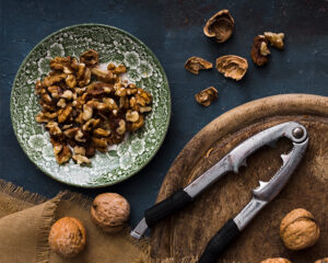 walnuts in shell and nutcracker on wooden board